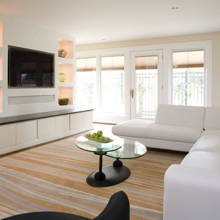 Example of a trendy family room design in DC Metro with beige walls and a media wall