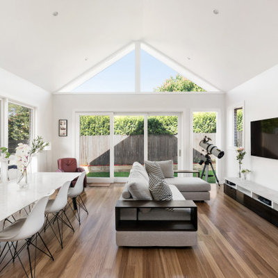 Inspiration for a mid-sized contemporary open concept family room remodel in Sydney with white walls and a wall-mounted tv