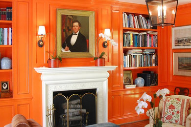 ダラスにある中くらいなエクレクティックスタイルのおしゃれな独立型ファミリールーム (オレンジの壁、無垢フローリング、標準型暖炉、木材の暖炉まわり、テレビなし、茶色い床) の写真