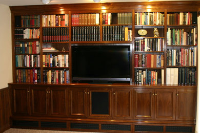 Imagen de sala de estar con biblioteca abierta tradicional de tamaño medio sin chimenea con paredes blancas, moqueta, televisor independiente y suelo beige