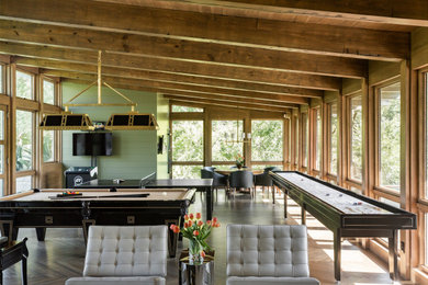 Offener Moderner Hobbyraum mit grüner Wandfarbe, braunem Holzboden, TV-Wand, braunem Boden, freigelegten Dachbalken und gewölbter Decke in Dallas