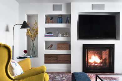 Example of a mid-sized trendy enclosed laminate floor and beige floor family room library design in Toronto with gray walls, a standard fireplace, a plaster fireplace and a media wall