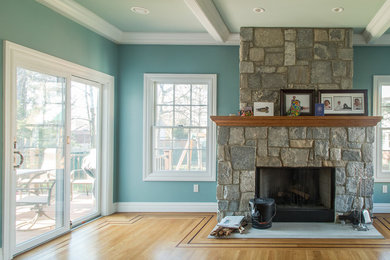 Diseño de sala de estar tradicional de tamaño medio con paredes azules, suelo de madera clara, todas las chimeneas, marco de chimenea de piedra y suelo beige