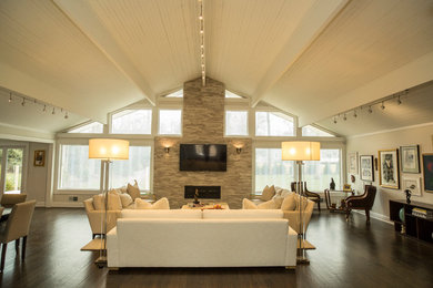 Example of a large trendy open concept dark wood floor and brown floor family room design in New York with gray walls, a ribbon fireplace, a stone fireplace and a wall-mounted tv