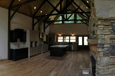 Foto de sala de estar abierta rústica extra grande con paredes blancas, suelo de madera clara, todas las chimeneas, marco de chimenea de piedra y suelo marrón