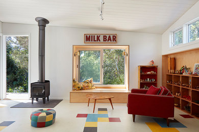 メルボルンにあるミッドセンチュリースタイルのおしゃれなファミリールーム (白い壁、薪ストーブ、金属の暖炉まわり、マルチカラーの床) の写真