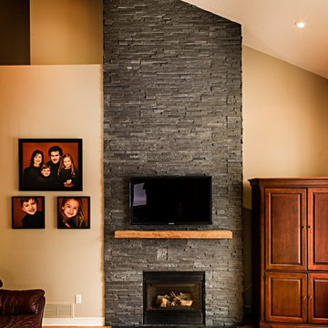 Dark Stone Veneer Fireplace with Wood Mantel
