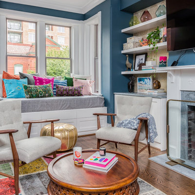 Example of an eclectic dark wood floor family room design in DC Metro with blue walls, a standard fireplace and a wall-mounted tv
