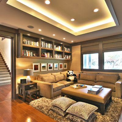 Example of a trendy medium tone wood floor family room design in Los Angeles with beige walls