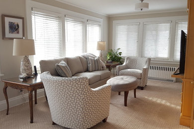 Modelo de sala de estar con biblioteca cerrada tradicional pequeña con paredes beige, moqueta, pared multimedia, suelo beige y alfombra