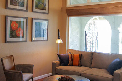 Imagen de sala de estar abierta actual grande sin televisor con parades naranjas y suelo de madera en tonos medios