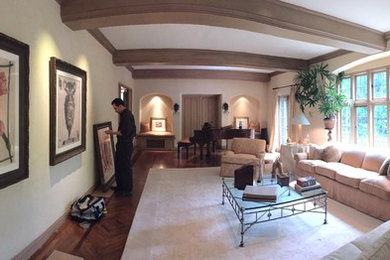 Imagen de sala de estar abierta minimalista grande sin chimenea con paredes beige, suelo de madera oscura y suelo beige