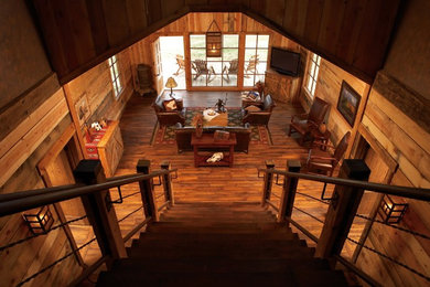 Inspiration for a large southwestern enclosed dark wood floor and brown floor family room remodel in Denver with a tv stand and brown walls