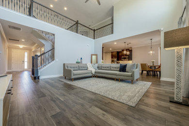 Inspiration for a large contemporary open concept medium tone wood floor and gray floor family room remodel in Orlando with gray walls, no fireplace and a tv stand