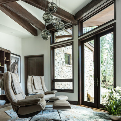 Mountain style light wood floor and beige floor family room photo in Denver with white walls