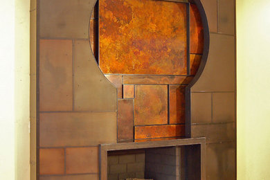 ロサンゼルスにあるコンテンポラリースタイルのおしゃれなファミリールーム (ベージュの壁、淡色無垢フローリング、標準型暖炉、金属の暖炉まわり) の写真