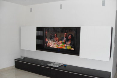 Modelo de sala de estar abierta contemporánea de tamaño medio sin chimenea con paredes blancas, suelo de baldosas de porcelana, televisor colgado en la pared y suelo beige