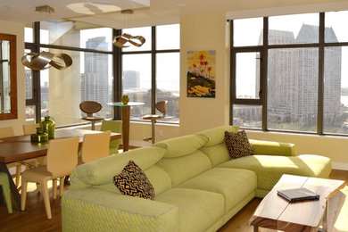 Immagine di un soggiorno minimalista di medie dimensioni e aperto con pareti beige, pavimento in legno massello medio, nessun camino e pavimento marrone