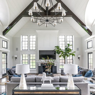 Example of a large transitional open concept medium tone wood floor and brown floor family room design in Chicago with white walls, a standard fireplace and a wall-mounted tv