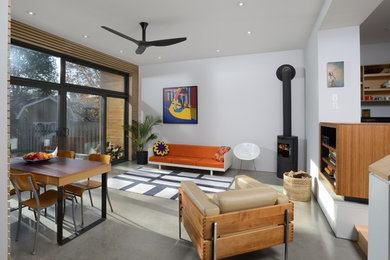 Ejemplo de sala de estar abierta minimalista con paredes blancas, suelo de cemento y chimenea lineal