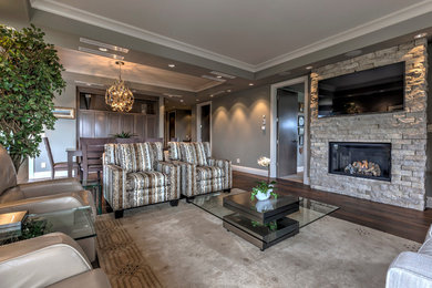 Foto de sala de estar moderna grande con paredes beige, suelo de madera oscura, todas las chimeneas, marco de chimenea de piedra y televisor colgado en la pared