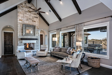 Family room - large transitional open concept dark wood floor and brown floor family room idea in Austin with gray walls, a two-sided fireplace, a stone fireplace and no tv