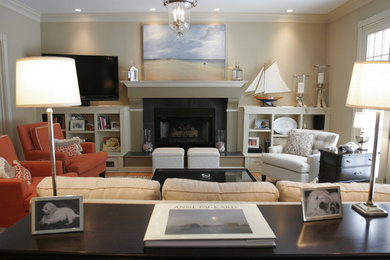 Foto de sala de estar abierta costera de tamaño medio con paredes beige, suelo de madera en tonos medios, todas las chimeneas, marco de chimenea de madera y televisor colgado en la pared