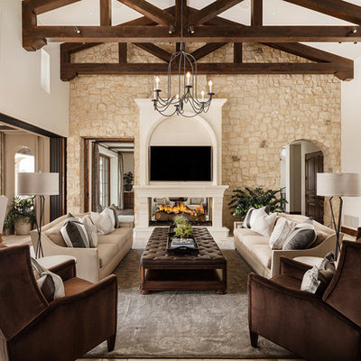 Family room - large mediterranean open concept travertine floor and beige floor family room idea in Phoenix with white walls, a two-sided fireplace, a wall-mounted tv and a stone fireplace