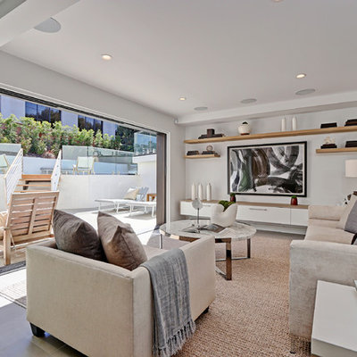 Mid-sized trendy open concept light wood floor family room photo in Los Angeles with a bar, white walls and a wall-mounted tv