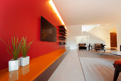 Diseño de sala de estar abierta moderna extra grande sin chimenea con paredes rojas y televisor colgado en la pared