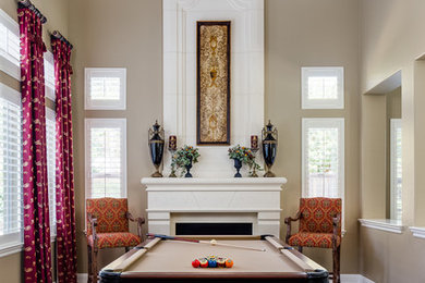 Photo of a large traditional enclosed games room in San Francisco with beige walls, dark hardwood flooring, a standard fireplace, a stone fireplace surround, no tv, a game room and brown floors.