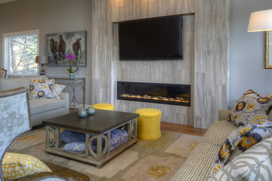 Inspiration for a mid-sized contemporary enclosed medium tone wood floor family room remodel in Denver with gray walls, a ribbon fireplace, a tile fireplace and a wall-mounted tv