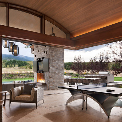 Inspiration for a rustic beige floor family room remodel in Denver with gray walls, a standard fireplace, a stone fireplace and a wall-mounted tv