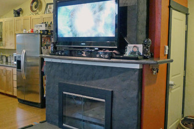 Foto de sala de estar abierta contemporánea de tamaño medio con paredes multicolor, suelo de bambú, todas las chimeneas, marco de chimenea de hormigón, televisor colgado en la pared y suelo marrón