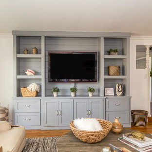 Example of a mid-sized transitional open concept medium tone wood floor family room design in Orange County with beige walls and a media wall