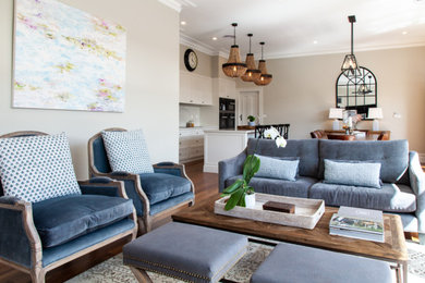 Foto de sala de estar abierta tradicional renovada grande con paredes beige, suelo de madera en tonos medios y suelo marrón