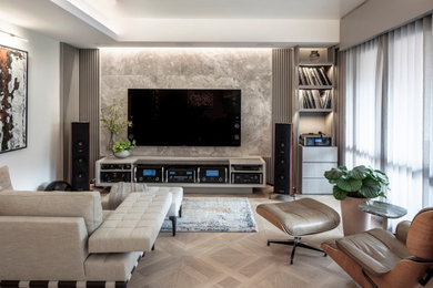Ejemplo de sala de estar abierta actual con paredes grises, suelo de madera clara, televisor colgado en la pared y suelo beige