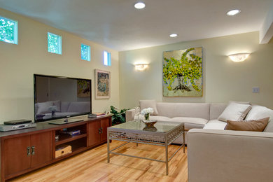 Example of a mid-sized minimalist open concept light wood floor and brown floor family room design in Denver with beige walls, no fireplace and a tv stand
