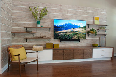 Ejemplo de sala de estar abierta vintage grande con suelo de madera en tonos medios, televisor colgado en la pared y paredes grises