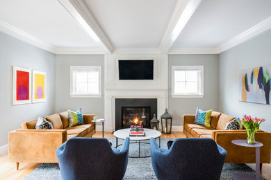 Traditional games room in Boston with grey walls, light hardwood flooring, a standard fireplace and a wall mounted tv.