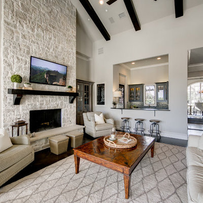 Inspiration for a large coastal open concept dark wood floor family room remodel in Dallas with gray walls, a standard fireplace, a stone fireplace and a wall-mounted tv