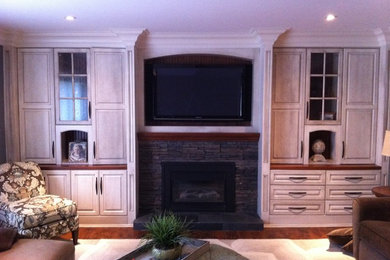 Mid-sized elegant enclosed dark wood floor family room photo in Toronto with white walls, a standard fireplace, a stone fireplace and a wall-mounted tv