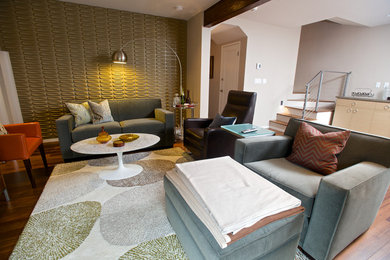 Imagen de sala de estar abierta contemporánea de tamaño medio sin chimenea con paredes grises, suelo de madera en tonos medios, televisor colgado en la pared y suelo marrón