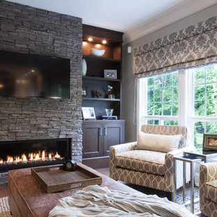Family room - large traditional medium tone wood floor family room idea in Vancouver with a stone fireplace, gray walls, a ribbon fireplace and a wall-mounted tv