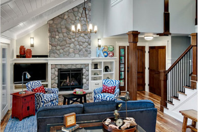 Family room - large traditional medium tone wood floor family room idea in Minneapolis with a stone fireplace
