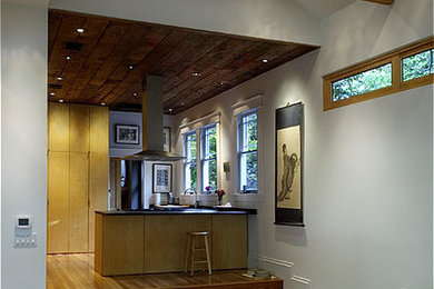 Imagen de sala de estar abierta de estilo americano con paredes blancas y suelo de madera en tonos medios