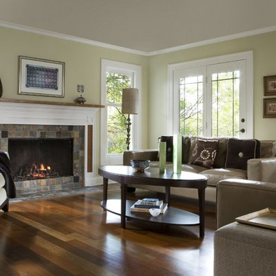 Inspiration for a contemporary medium tone wood floor and brown floor family room remodel in Detroit with beige walls, a standard fireplace and no tv