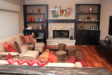 Modelo de sala de estar cerrada contemporánea de tamaño medio sin chimenea con paredes beige, suelo de madera oscura, televisor colgado en la pared y suelo marrón