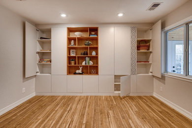 Modelo de sala de estar cerrada minimalista de tamaño medio sin chimenea con paredes beige, suelo laminado y suelo marrón