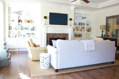 Aménagement d'une salle de séjour classique ouverte avec un mur blanc, un sol en bois brun et un téléviseur fixé au mur.